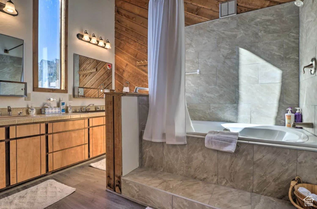 Bathroom featuring wood-type flooring, vanity, and independent shower and bath