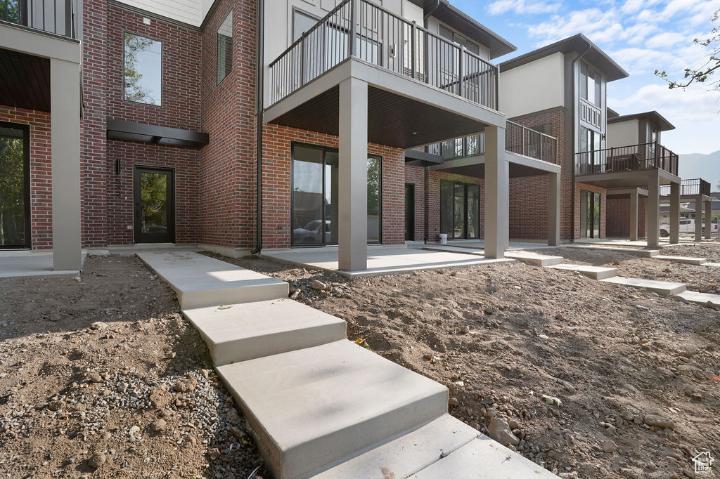 Rear view of house featuring a balcony and a patio