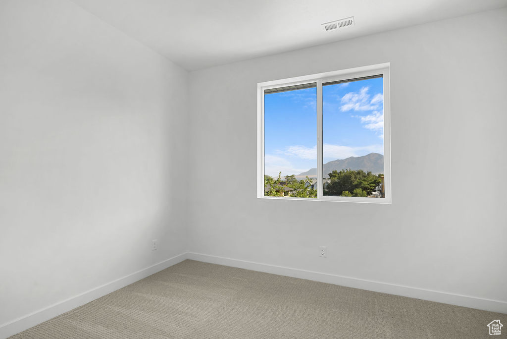 Spare room featuring light carpet and a mountain view