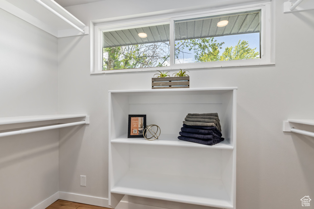 Walk in closet with wood-type flooring