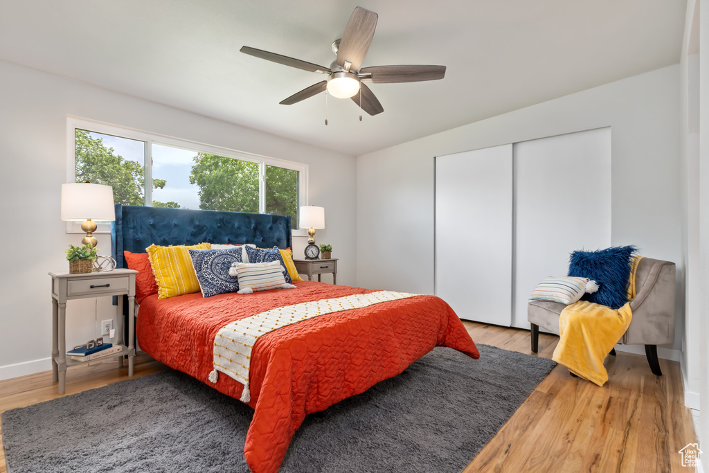 Bedroom with a closet, hardwood / wood-style flooring, and ceiling fan