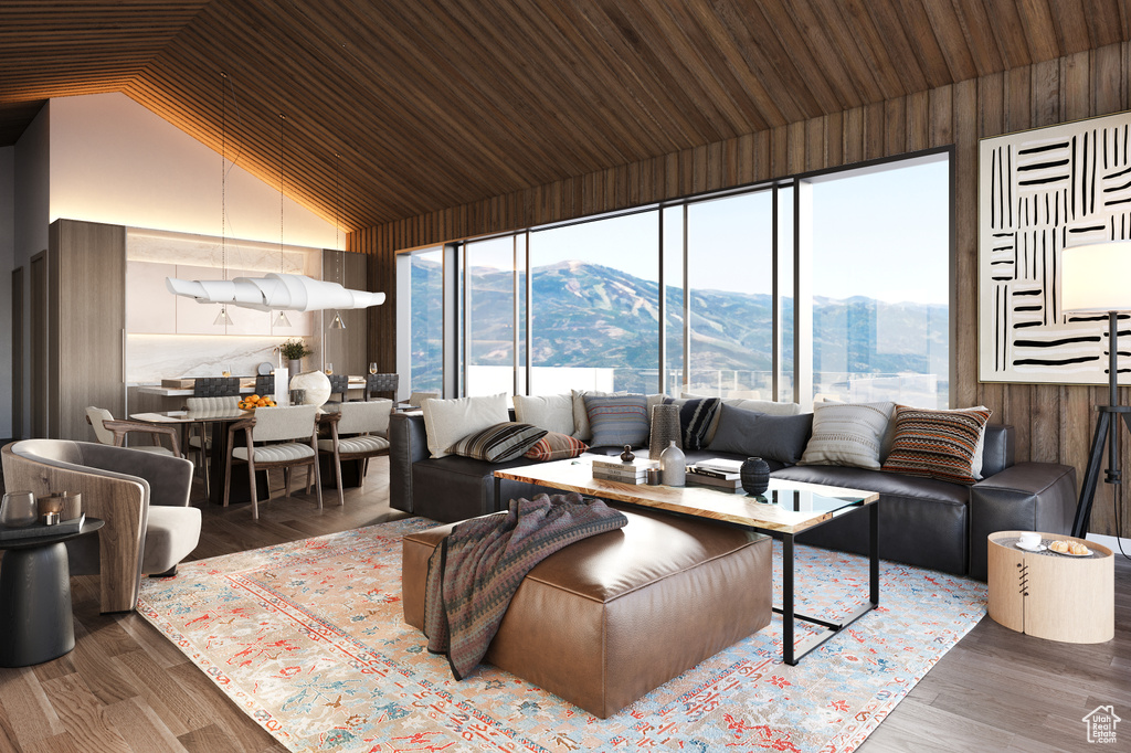 Living room featuring wooden walls, a mountain view, hardwood / wood-style flooring, and plenty of natural light