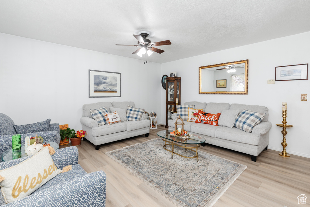 Living room with light hardwood / wood-style flooring and ceiling fan