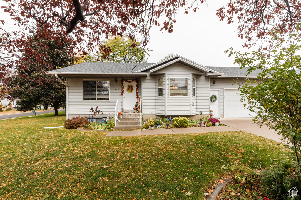 Ranch-style home featuring a front yard and a garage