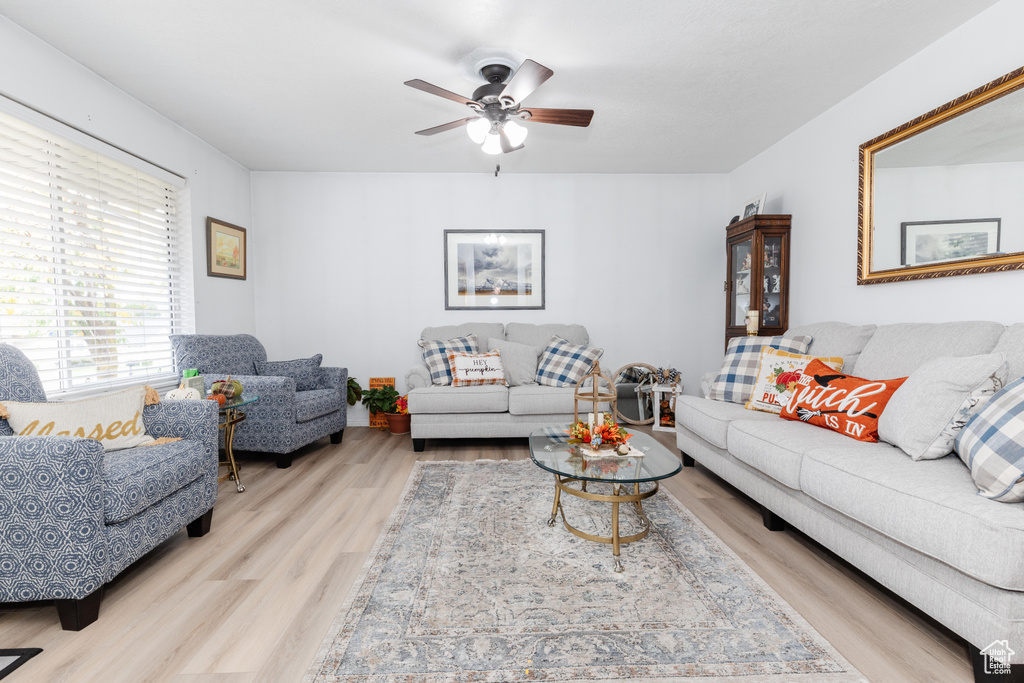 Living room with light hardwood / wood-style flooring and ceiling fan