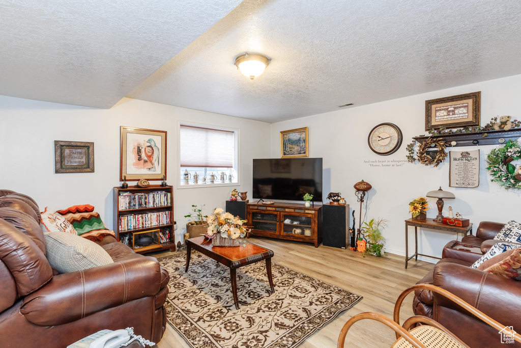 Living room with wood-type flooring and a textured ceiling