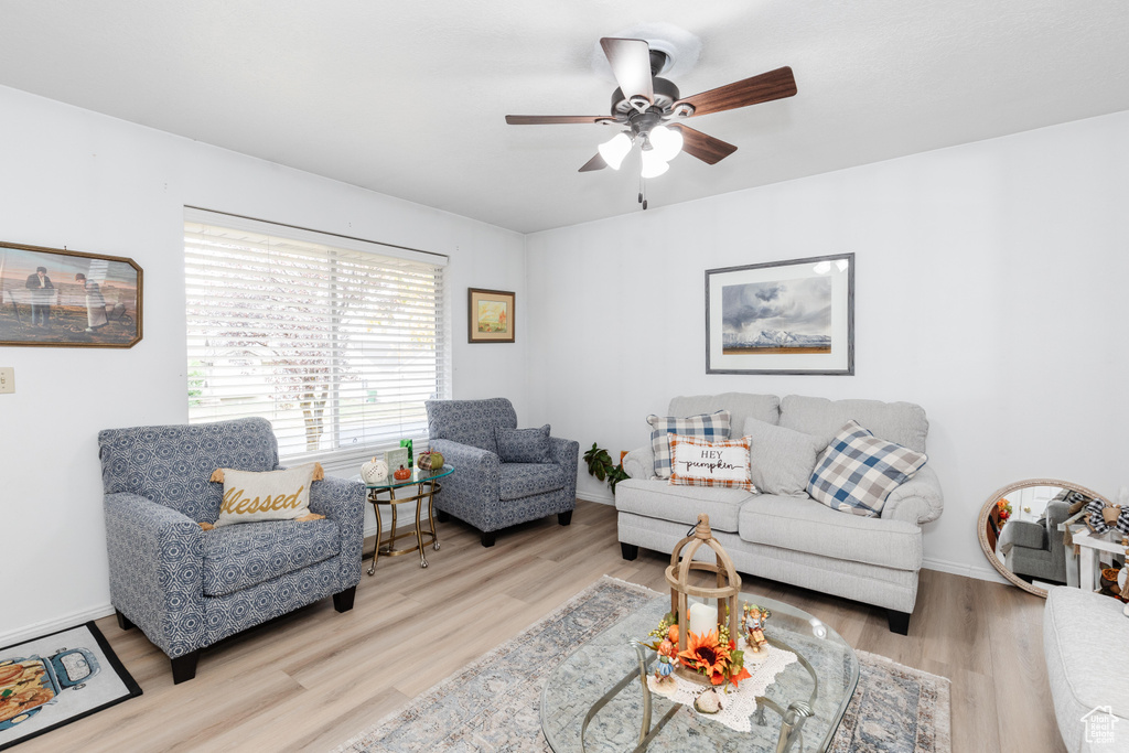 Living room with ceiling fan and light hardwood / wood-style flooring