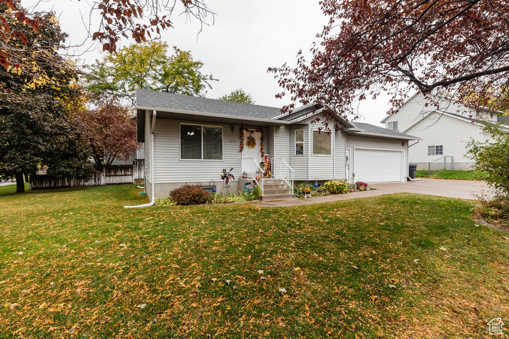 Ranch-style home with a front yard and a garage