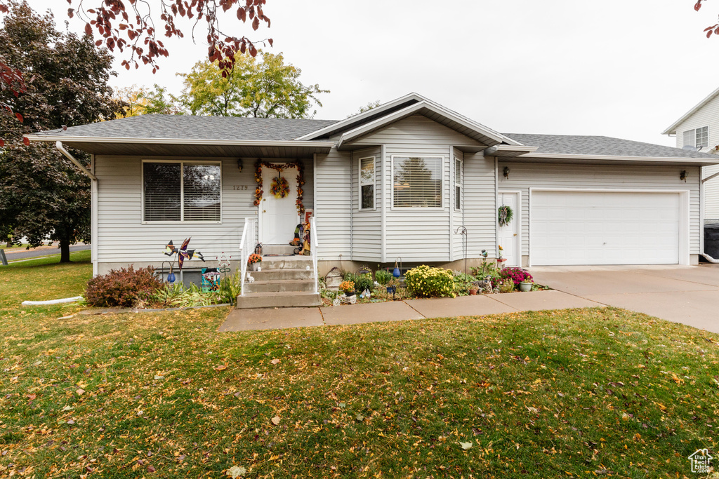 Ranch-style house featuring a front lawn and a garage