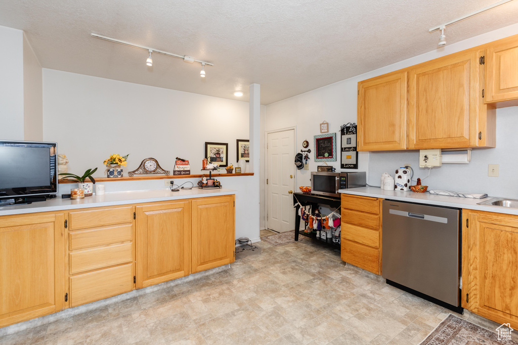 Kitchen featuring stainless steel appliances, track lighting, and light brown cabinetry