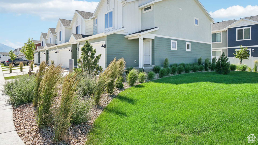 View of side of home featuring a yard and a garage