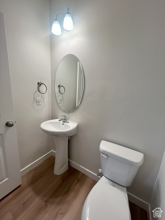 Bathroom featuring hardwood / wood-style flooring and toilet