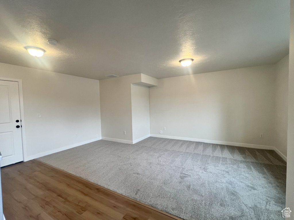 Empty room featuring hardwood / wood-style flooring and a textured ceiling