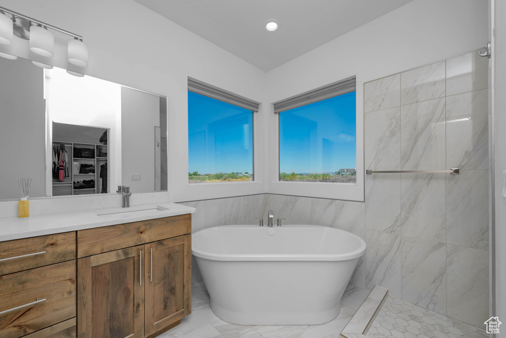 Bathroom with vanity, plus walk in shower, and tile walls