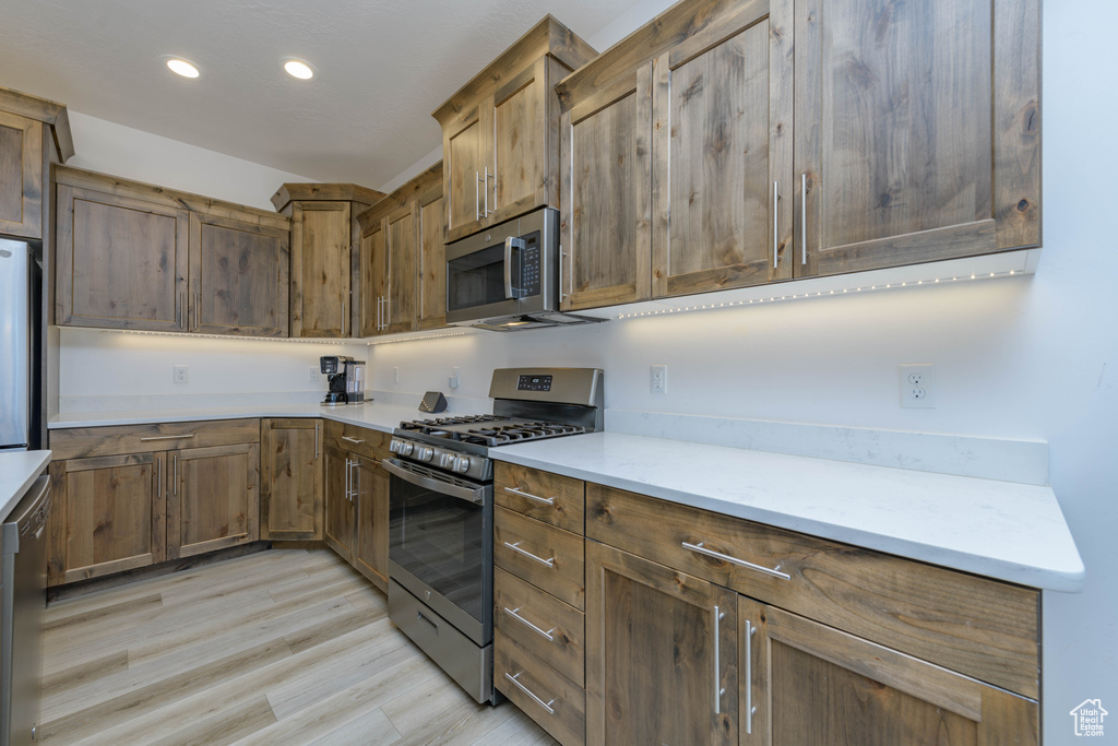 Kitchen featuring appliances with stainless steel finishes and light hardwood / wood-style flooring