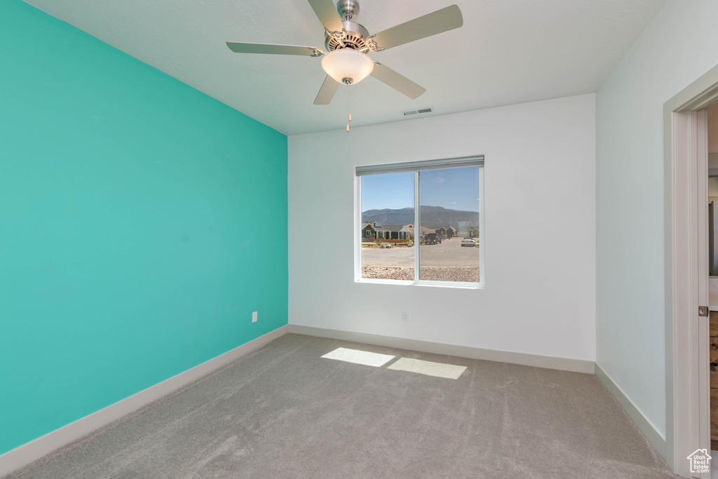 Carpeted spare room with ceiling fan