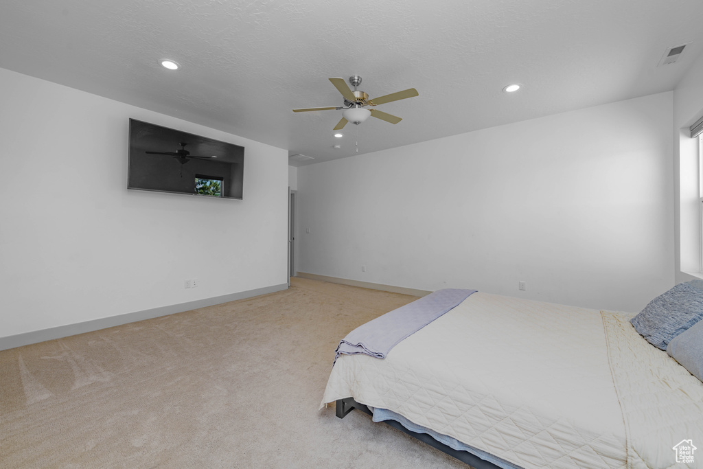 Carpeted bedroom featuring ceiling fan