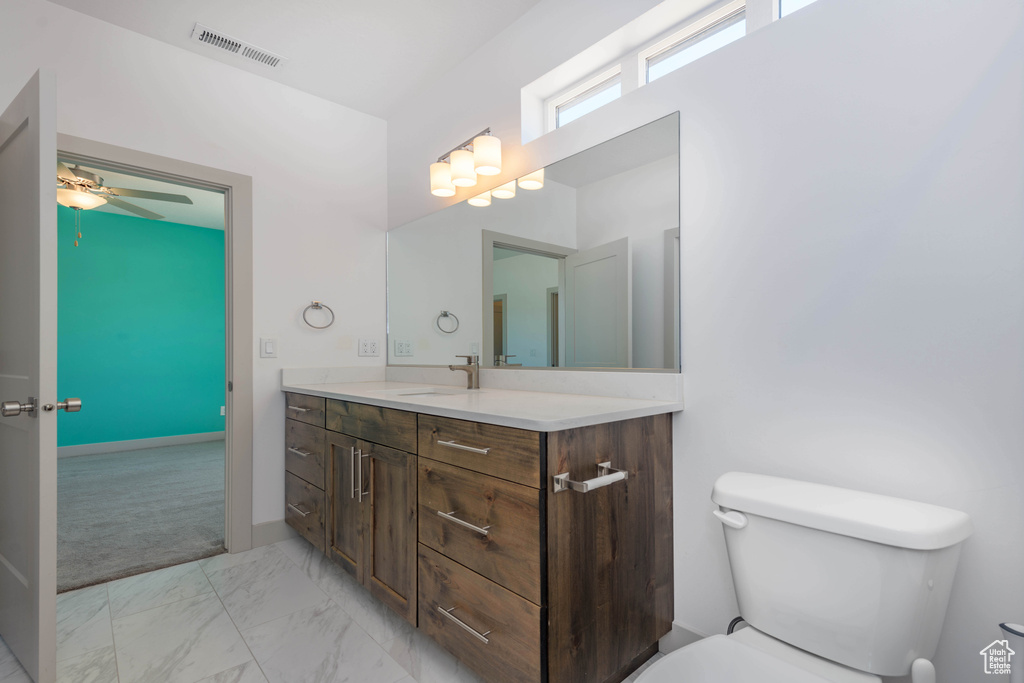 Bathroom with vanity, toilet, and ceiling fan