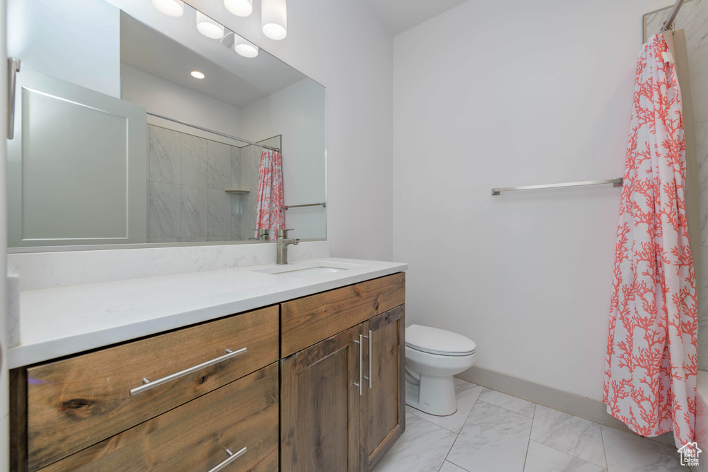 Bathroom with vanity, curtained shower, and toilet