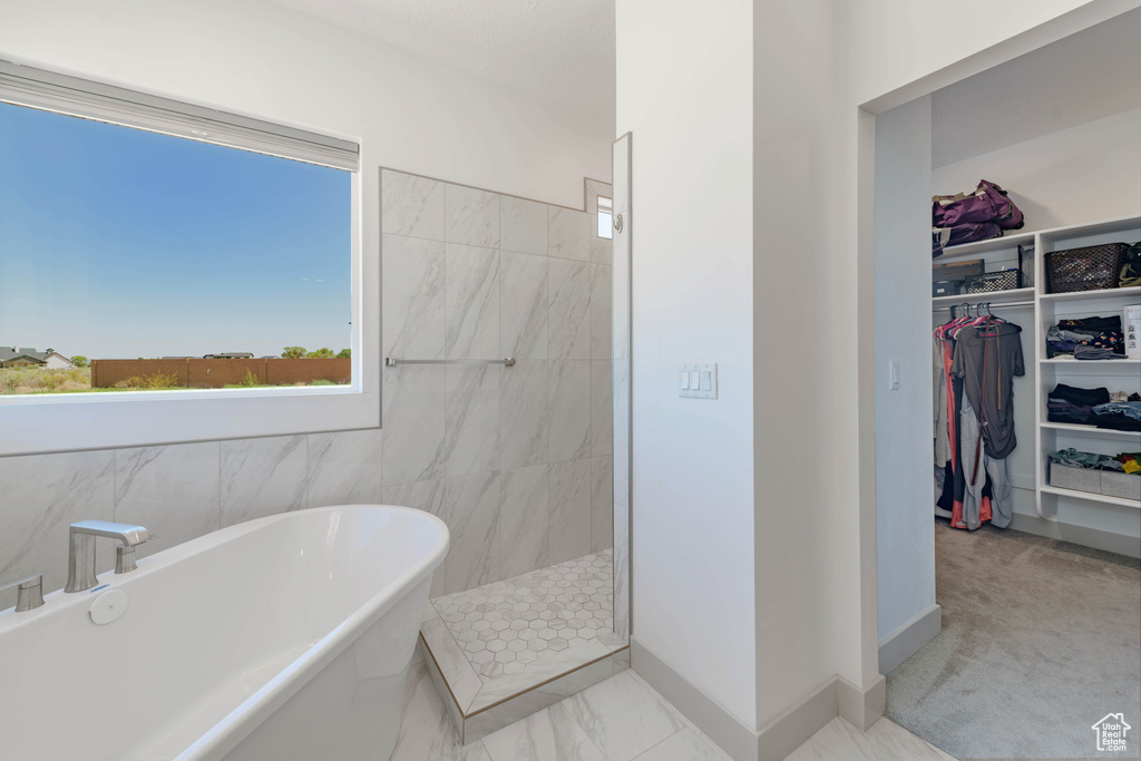 Bathroom featuring shower with separate bathtub