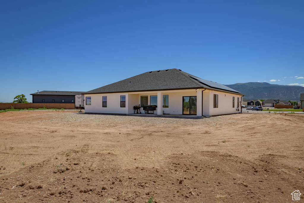 Back of property with a mountain view and a patio area