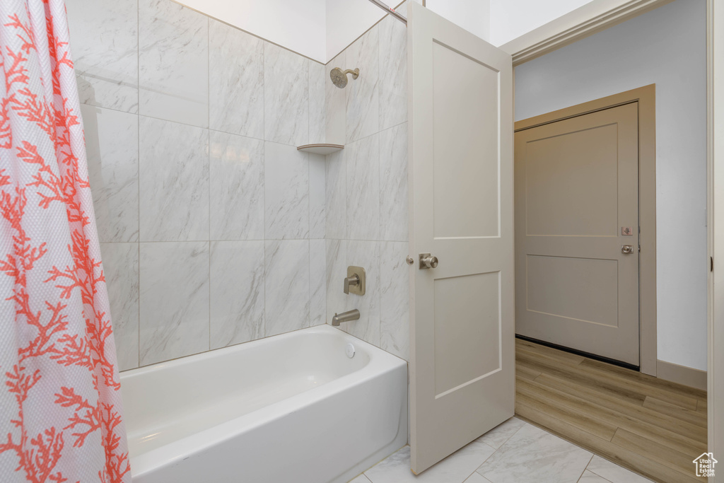 Bathroom featuring shower / bath combo with shower curtain and hardwood / wood-style floors