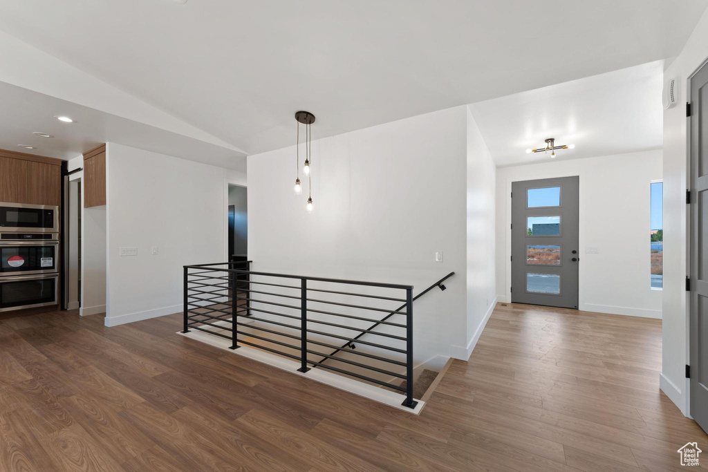 Corridor featuring dark wood-type flooring and vaulted ceiling