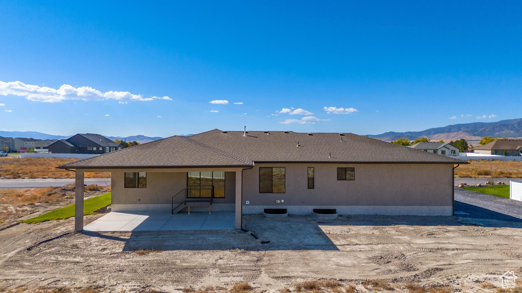 Rear view of property with a mountain view and a patio area
