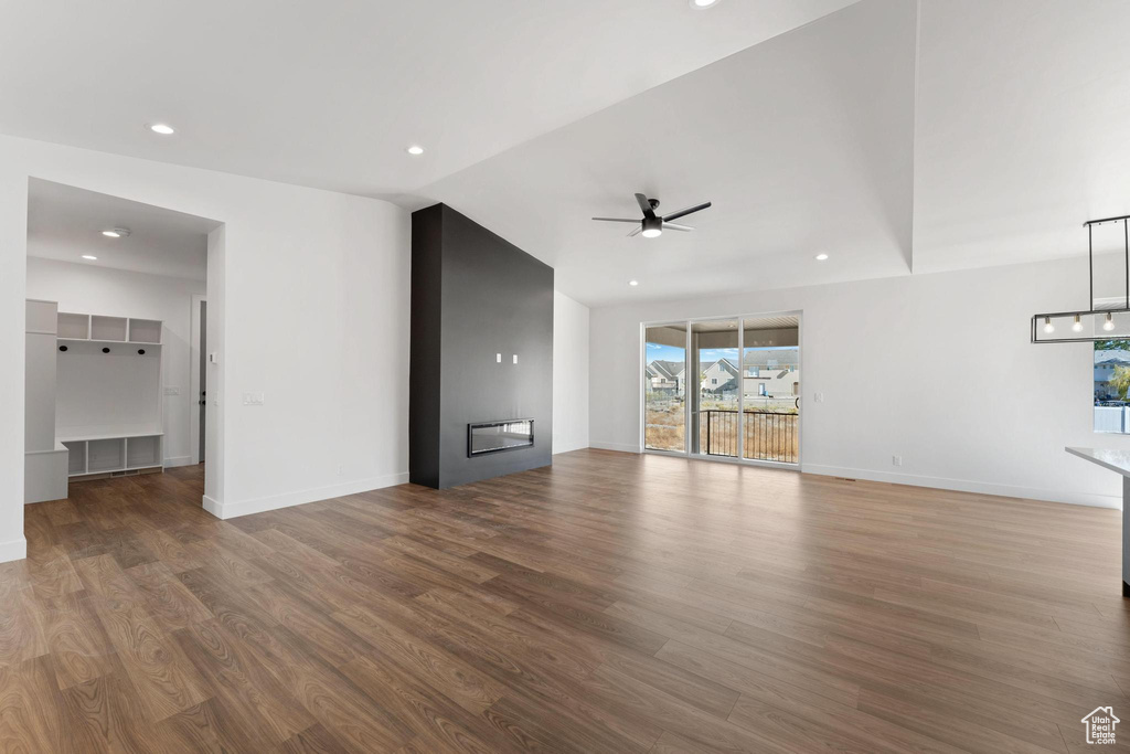 Unfurnished living room featuring ceiling fan, hardwood / wood-style flooring, and lofted ceiling