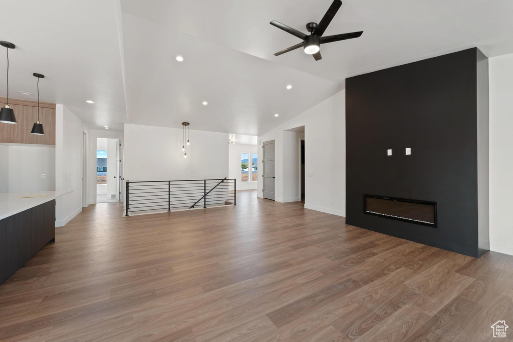 Unfurnished living room featuring light hardwood / wood-style flooring and vaulted ceiling