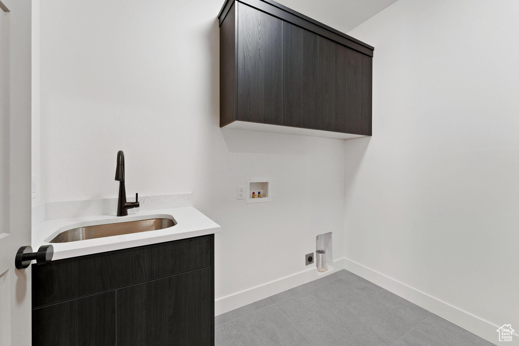 Laundry area featuring hookup for an electric dryer, sink, washer hookup, and cabinets