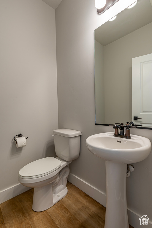 Bathroom featuring toilet, hardwood / wood-style flooring, and sink