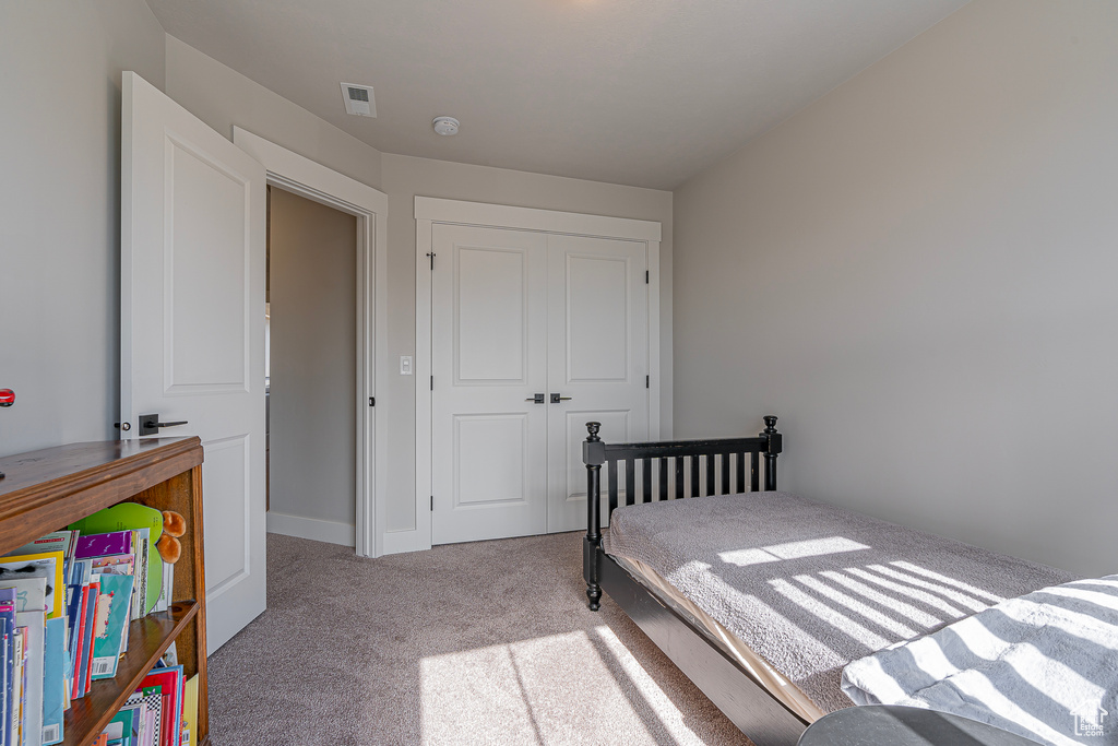 Bedroom with a closet and light colored carpet