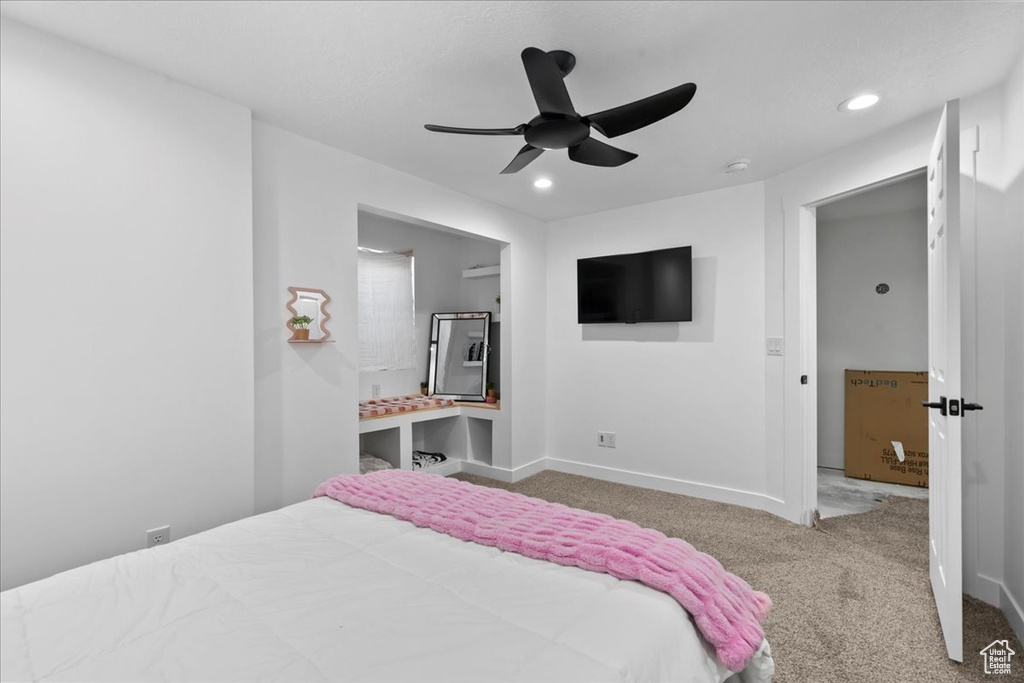 Carpeted bedroom featuring ceiling fan