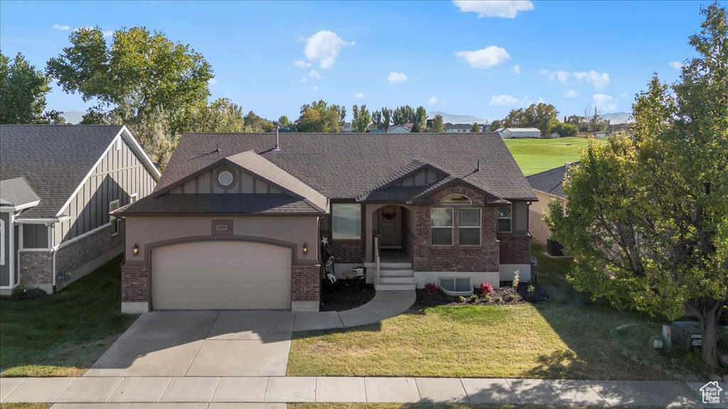 View of front facade featuring a front lawn, central AC, and a garage