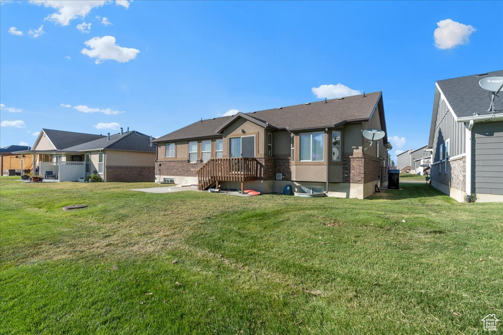 Rear view of house featuring a lawn