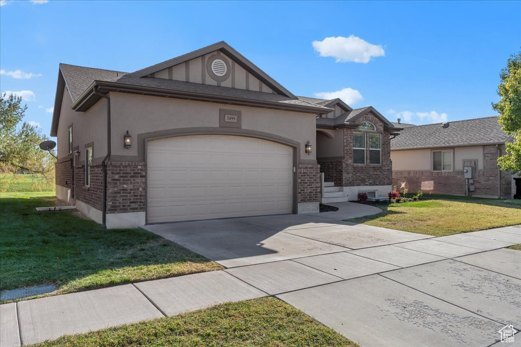 Ranch-style home featuring a front yard and a garage