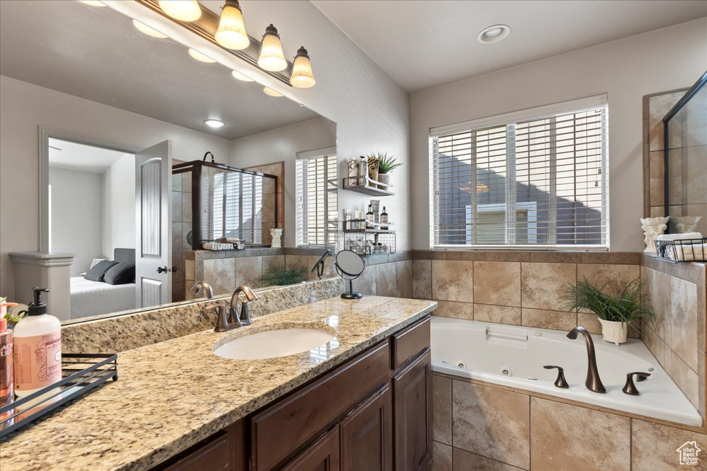 Bathroom featuring vanity and independent shower and bath