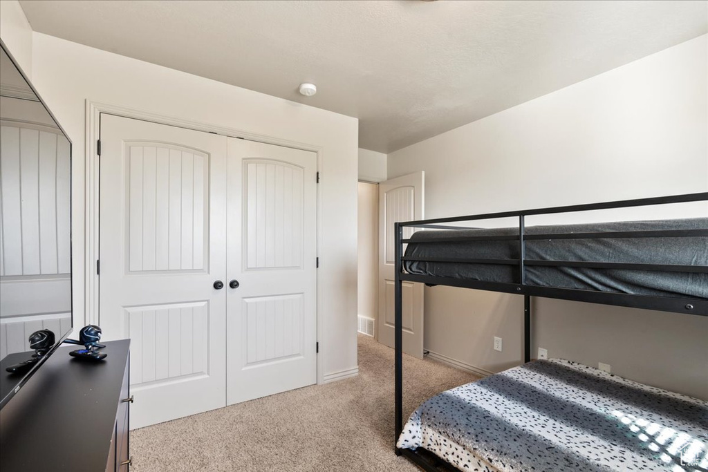 Carpeted bedroom with a closet