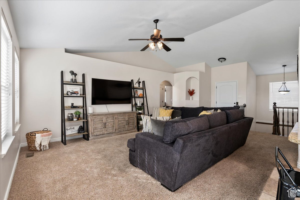 Carpeted living room featuring ceiling fan and lofted ceiling