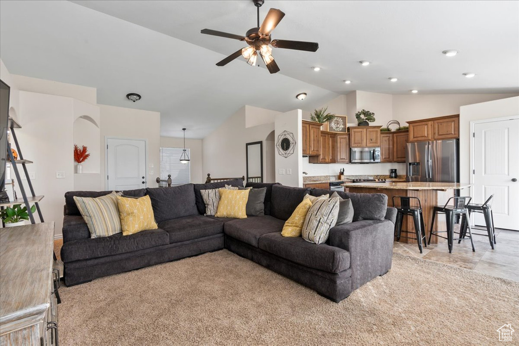 Living room featuring light carpet, vaulted ceiling, and ceiling fan