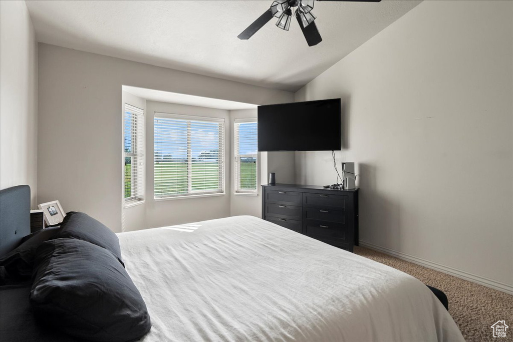 Bedroom featuring ceiling fan, carpet flooring, and lofted ceiling