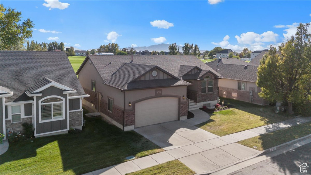 View of front of property featuring a front lawn and a garage