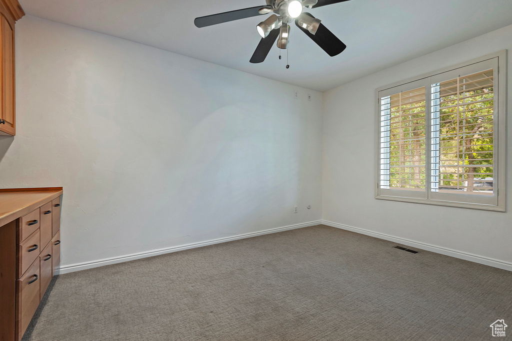 Empty room featuring light carpet and ceiling fan