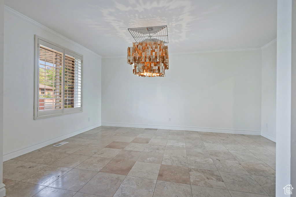 Unfurnished room with a notable chandelier and ornamental molding