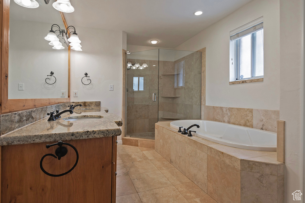 Bathroom featuring vanity, a chandelier, shower with separate bathtub, and tile patterned flooring