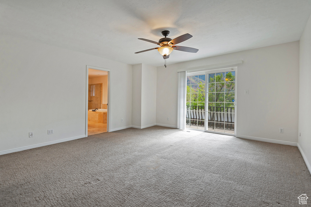 Empty room featuring carpet flooring and ceiling fan