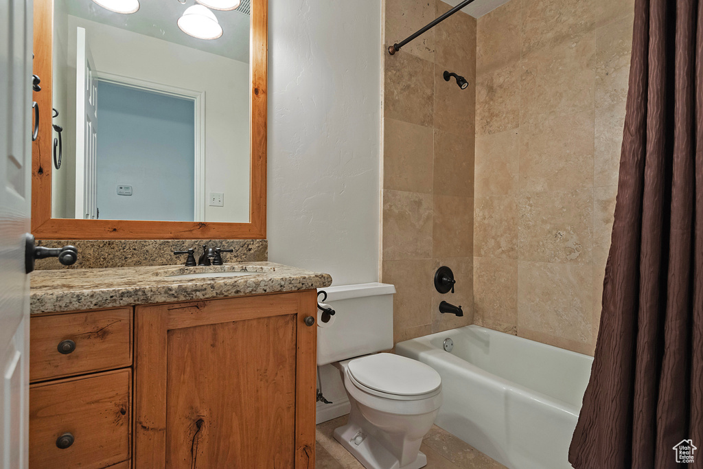 Full bathroom featuring toilet, vanity, and shower / tub combo