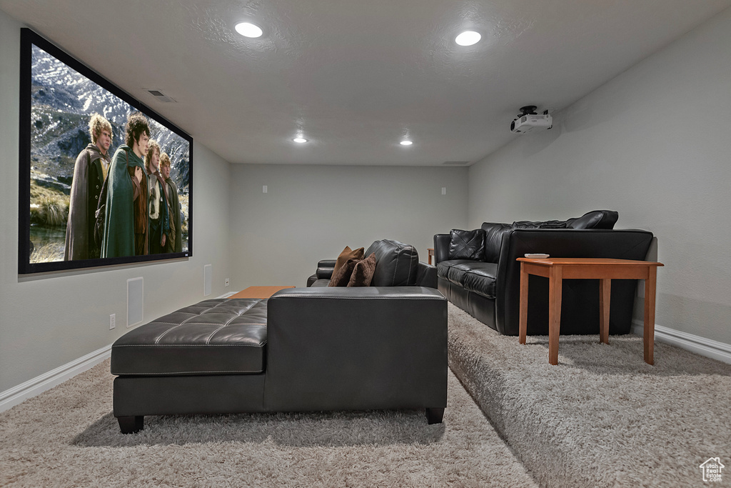 Home theater with a textured ceiling and light colored carpet