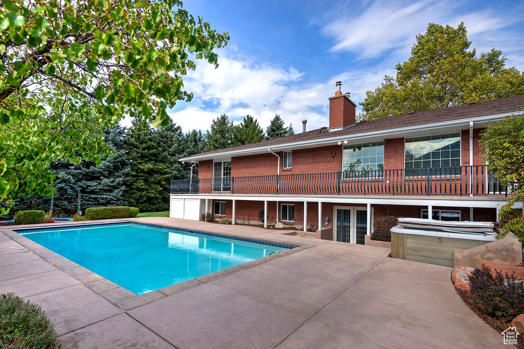 View of pool featuring a patio and a hot tub